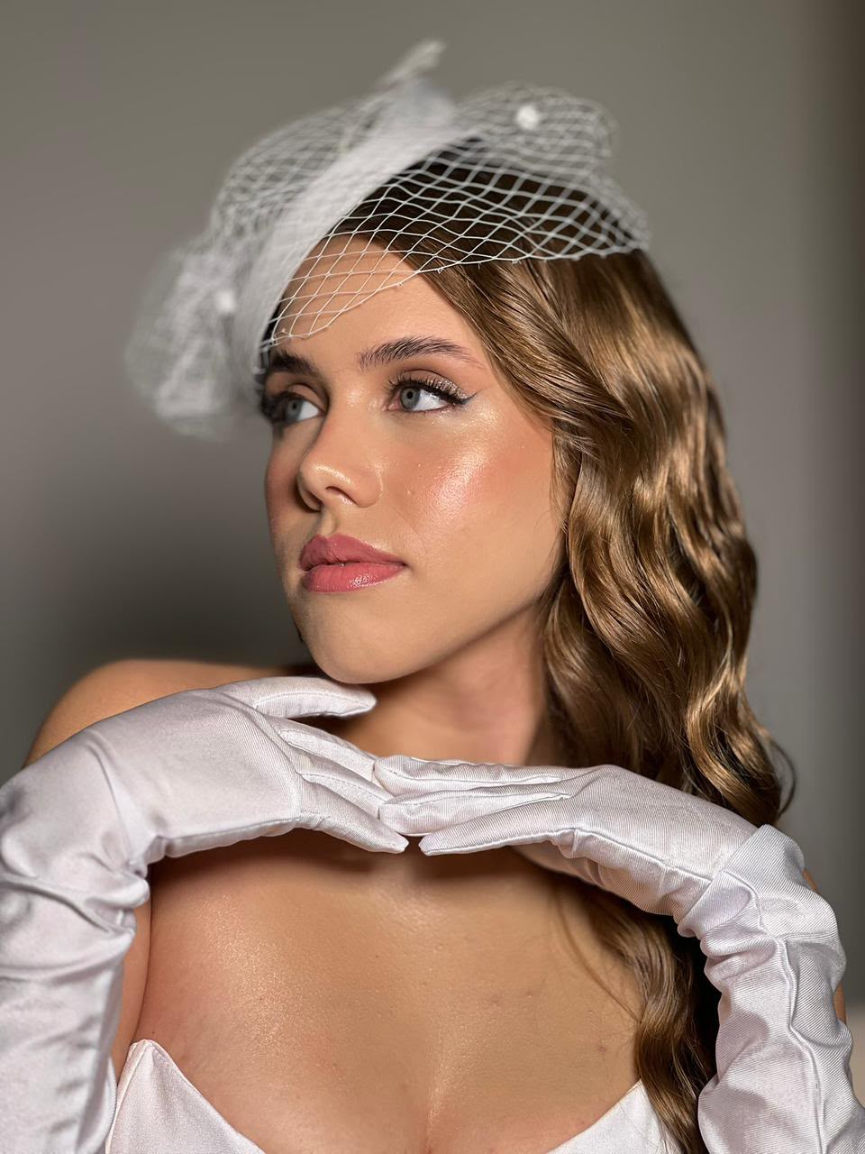 Retrato editorial com fascinator e luvas